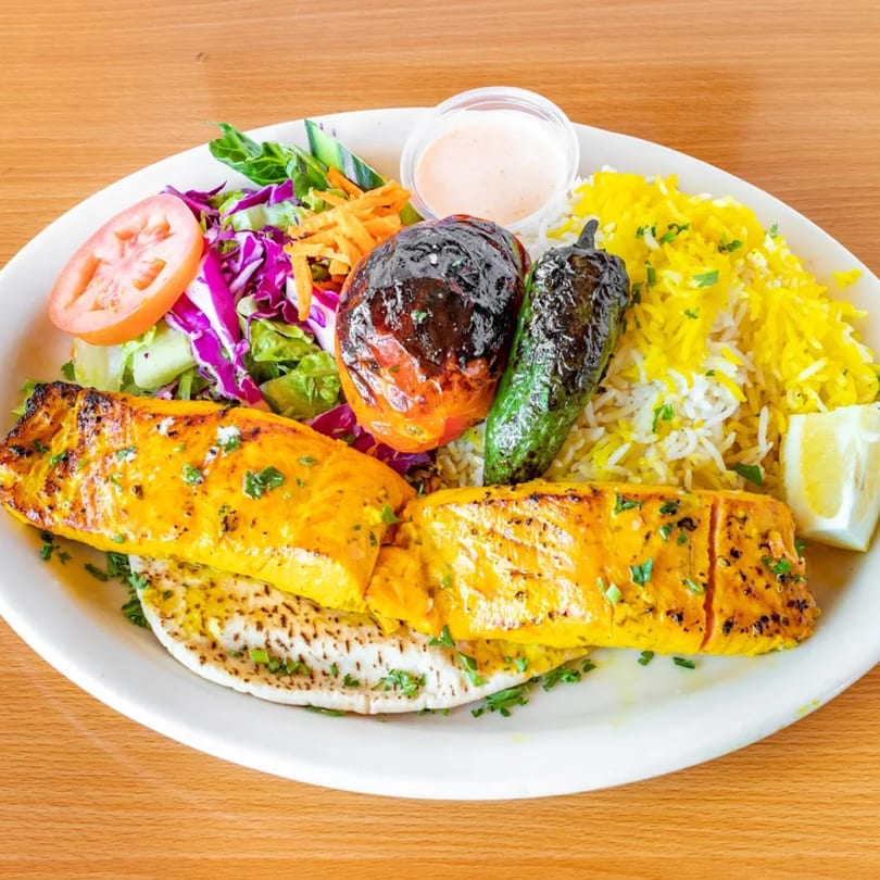 Fanoos Grill's Persian salmon kabob with saffron rice, grilled vegetables, and salad.